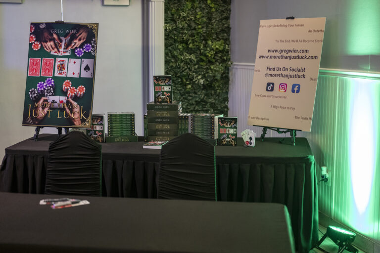 Book release party: Book display table with an easel sign and playing-card art
