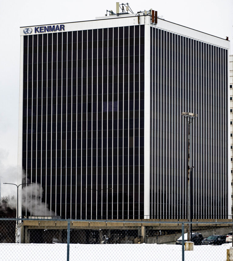 Black glass office tower with a Kenmar sign
