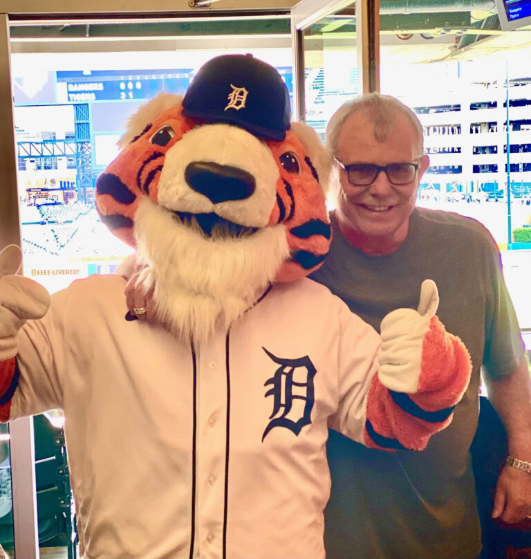 A man giving a thumbs-up beside the Detroit Tigers mascot