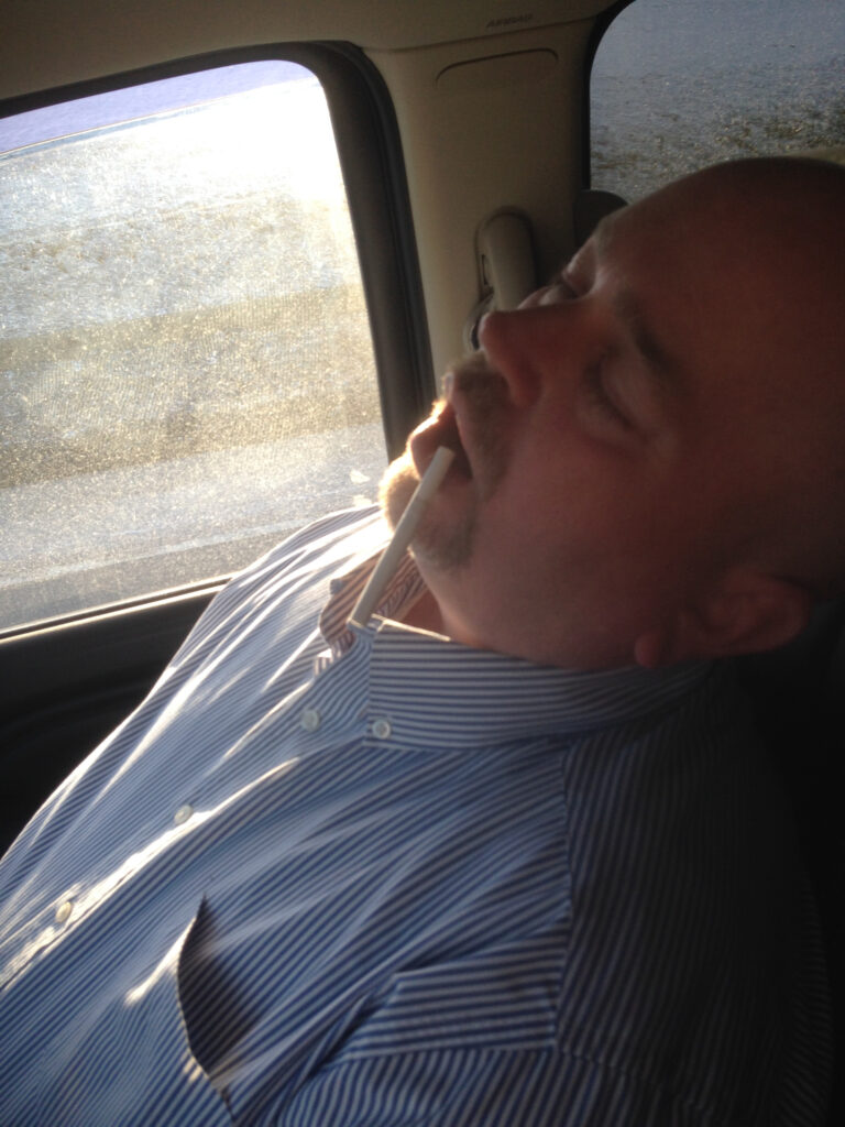 A man asleep in a car seat