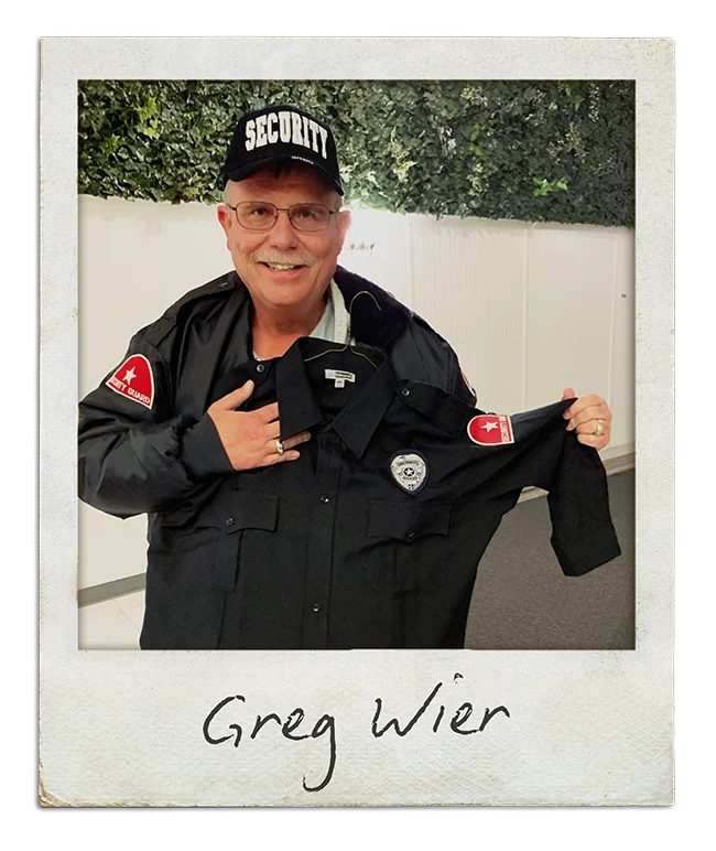 Polaroid captioned "Greg Wier": a man in a security cap and jacket holding up a security shirt