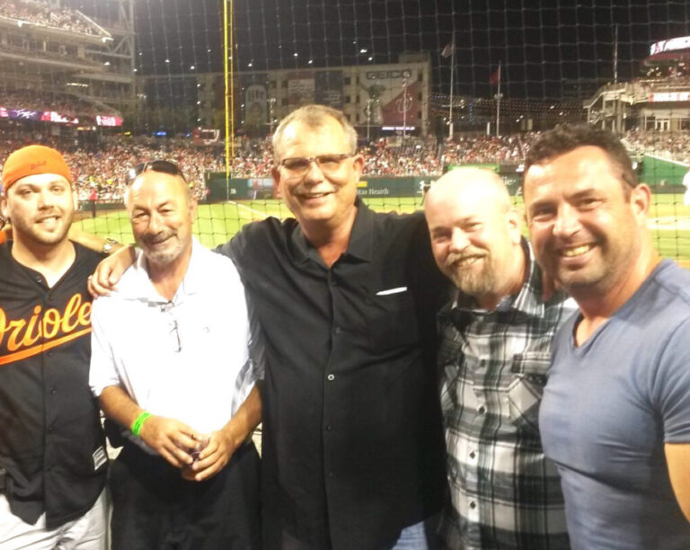 Five men at a baseball stadium at night