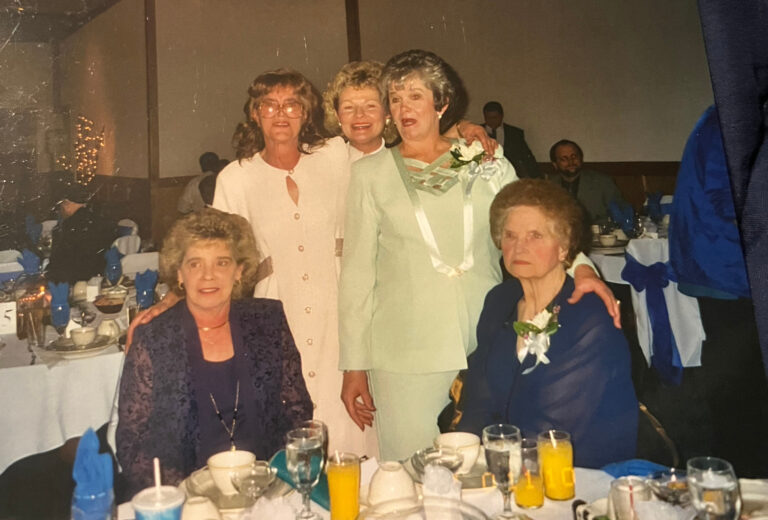 Women posing at a banquet table